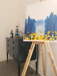 a painting on a easel next to a dresser at Dimora Storica Apartments in Ruviano