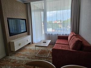 a living room with a red couch and a tv at Ferienwohnung Ostseekult in Międzyzdroje