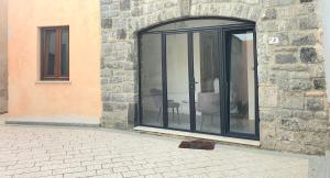 a glass door with a chair inside of a building at Dimora Storica Apartments in Ruviano