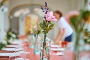 a table with a vase with flowers in it at Engelwirt Hotel & Apartments in Berching