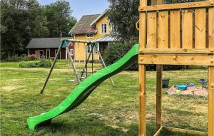 un parco giochi con scivolo verde in un cortile di Three-Bedroom Holiday Home In Sodra Vi a Södra Vi