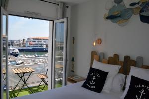 a bedroom with a bed and a view of a harbor at Atlantic Hôtel - L'Ile d'Yeu in L'Ile d'Yeu
