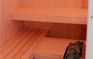 eine kleine Sauna mit Holzregalen und Felsen in der Unterkunft Freibeuterweg 18 - Dorf 5 in Travemünde