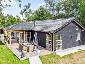 Un gran cobertizo negro con terraza. en 5 star holiday home in Væggerløse-By Traum, en Bøtø By