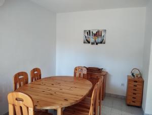 a wooden dining room table with chairs and a cabinet at Holiday house Pinus Pinea in Viganj