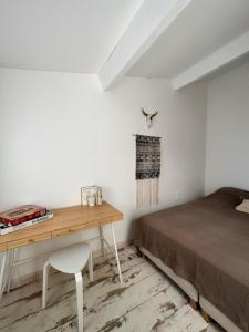 a bedroom with a bed and a wooden desk at Appartement cosy Le Bohème, à 300m des plages LOCAMARGUE in Saintes-Maries-de-la-Mer