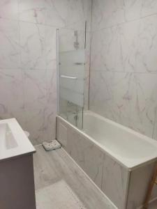 a white bathroom with a tub and a sink at Maison spacieuse à Domeyrat + grand jardin in Domeyrat