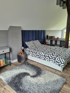 a bedroom with a bed with a black and white blanket at Chill in Lubrza in Lubrza