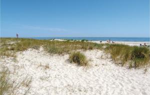 a sandy beach with grass and the ocean in the background at Two-Bedroom Holiday Home In Hollviken in Höllviken +8 photos