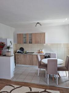 莫斯塔尔Portofino Guest House Blagaj的房间里有一张桌子和几把椅子的厨房