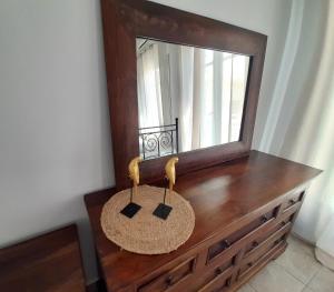 - une commode en bois avec un miroir au-dessus dans l'établissement Louisa's Home, à Ermoúpoli 8 autres photos