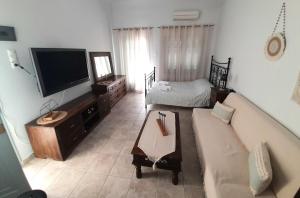 un salon avec un canapé et une télévision à écran plat dans l'établissement Louisa's Home, à Ermoúpoli