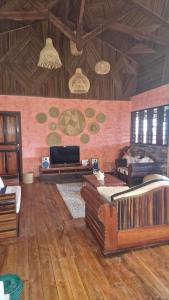 a living room with wood floors and a room with couches at Villa ecolodge sur l ile de nosy komba in Nosy Komba