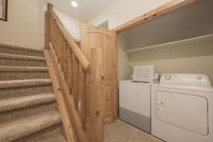 a laundry room with stairs and a washer and dryer at 103 Antler Way at Lakota townhouse in Winter Park