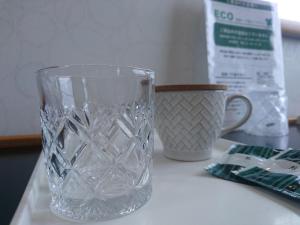a glass vase sitting on a counter next to a mug at Terminal Hotel Matsuyama in Matsuyama