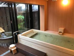 una vasca idromassaggio in una camera con finestra di Ryokan Miyoshi a Nagoya