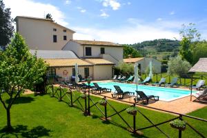a pool in a yard with chairs and a house at Residenza Porta Guelfa in Bevagna