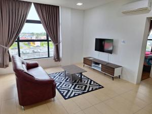 a living room with a chair and a television at Bunny Homestay 404 @ Roxy Apartment Kuching in Kuching