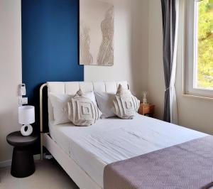 a bedroom with a white bed with a blue wall at Residence Panorama Palinuro in Palinuro