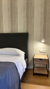 a bed with a black headboard and a table next to it at La Pennichella Vista Veneto in Agropoli +10 photos