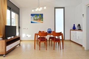 een eetkamer met een tafel, stoelen en een tv bij AT014 A pocos metros de la playa, equipamiento completo, piscina comunitaria in Torredembarra