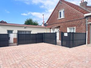 ロンゴーにあるL' authentique Clémentの煉瓦造りの家の前の黒い柵