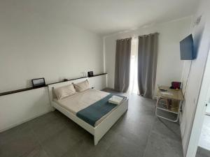 a white bedroom with a bed and a window at La Casa di Cloe in La Spezia