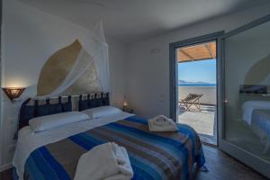 sypialnia z łóżkiem i widokiem na ocean w obiekcie Ajamola w mieście Favignana