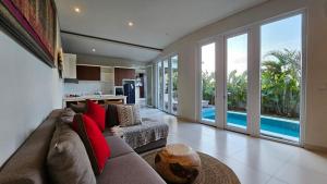 un salon avec un canapé et une cuisine dans l'établissement Araya Luxe Villa, à Munggu