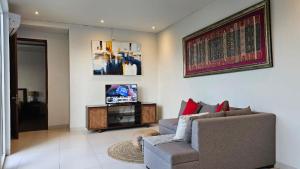 un salon avec un canapé et une télévision dans l'établissement Araya Luxe Villa, à Munggu