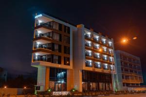 a tall building with lights on it at night at Cozy Loft Hotel in Batumi