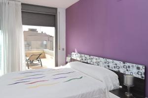 een slaapkamer met paarse muren en een wit bed bij AT014 A pocos metros de la playa, equipamiento completo, piscina comunitaria in Torredembarra +21 foto's