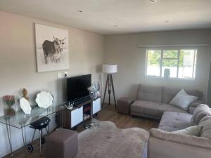 een woonkamer met een bank en een tafel bij Royal Mountain Apartment in Paarl