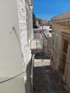 une ruelle entre deux bâtiments avec un balcon dans l'établissement Louisa's Home, à Ermoúpoli