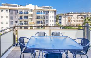 a blue table and chairs on a balcony with buildings at 2 Bedroom Lovely Apartment In Oliva in Oliva