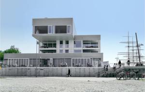 a building on the beach with people walking in front of it at Priwallpromenade 1, Whg 3 in Travemünde +32 photos