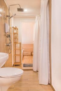 a bathroom with a white shower curtain and a toilet at Antim Boutique Apartments in Sofia