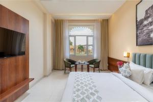 a hotel room with a bed and a table with chairs at Turban Roopgarh Resort and Spa, Udaipur in Udaipur