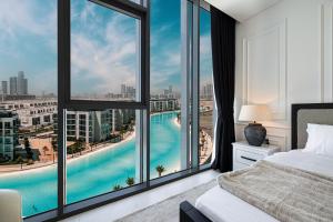 una camera da letto con vista sulla piscina attraverso le finestre di Crystal Lagoon View Beach access Fast Wi-Fi a Dubai