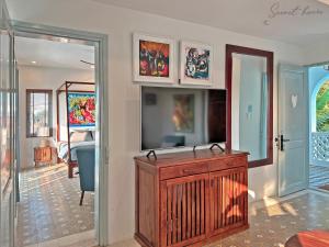 a living room with a flat screen tv on a wall at Secret House Boutique Hoi An in Hoi An