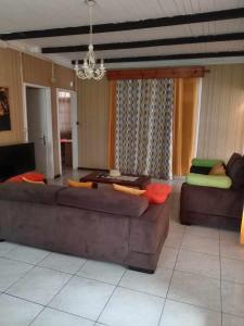 a living room with a couch and a table at Grande Maison atypique proche du Maïdo in Saint-Paul