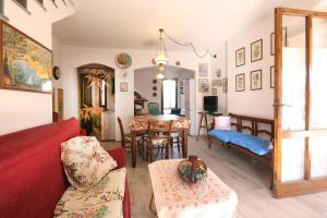 Una sala de estar con un sofá rojo y un comedor. en Villetta bifamiliare nel verde a Pietrasanta, en Pietrasanta
