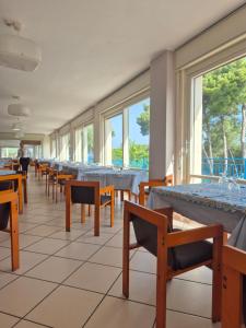 ein Esszimmer mit Tischen, Stühlen und Fenstern in der Unterkunft Hotel Guardacosta in Diamante