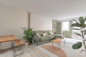 ein Wohnzimmer mit einem grünen Sofa und einigen Pflanzen in der Unterkunft Luxe et Design avec parking gratuit in Lyon + 19 Fotos