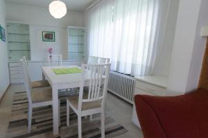 a white dining room with a white table and chairs at Chalet Center Pic in Ortisei