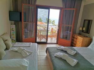 a hotel room with two beds and a balcony at Happiness House in Kallithea Halkidikis