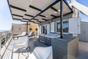a house with a balcony with chairs and tables at Jacuzzi Luxpenthouse PFaliro in Athens