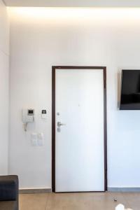 a white door in a room with a tv at Jacuzzi Luxpenthouse PFaliro in Athens