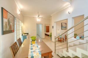 a dining room with a table and a staircase at The Oval House, Kochi - Approved by Kerala Tourism - Exclusively for Families in Cochin