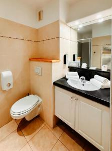 a bathroom with a toilet and a sink at Tulip Inn Honfleur Residence & Spa in Honfleur